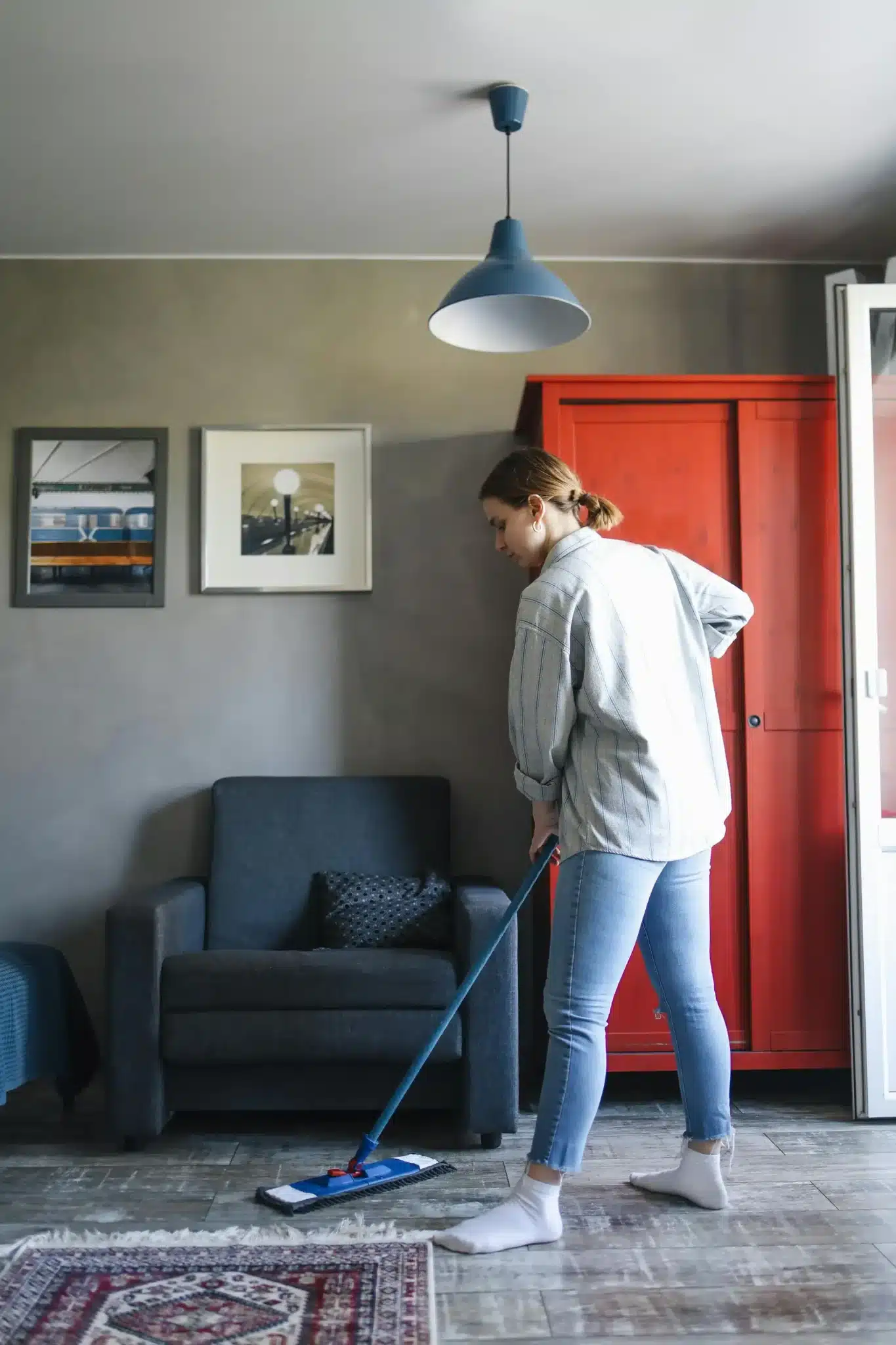 Professional cleaner mopping the living room floor in a cozy home