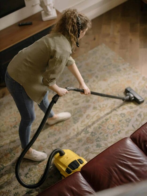 a lady Heavy Duty Cleaner is cleaning a carpet for providing Heavy Duty Carpet Cleaning